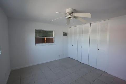 1050 East Sample Road, Unit 101 Pompano Beach, FL 33064 - Photo 18 of 19 an empty room with a fan & a window