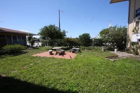 1050 East Sample Road, Unit 101 Pompano Beach, FL 33064 - Photo 19 of 19 a view of a house with backyard and sitting area
