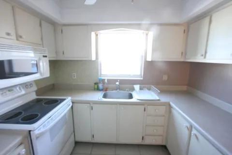 1050 East Sample Road, Unit 101 Pompano Beach, FL 33064 - Photo 6 of 19 a kitchen with a sink stove top oven and cabinets