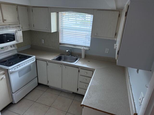1050 East Sample Road, Unit 101 Pompano Beach, FL 33064 - Photo 9 of 24 a kitchen with cabinets appliances and a sink