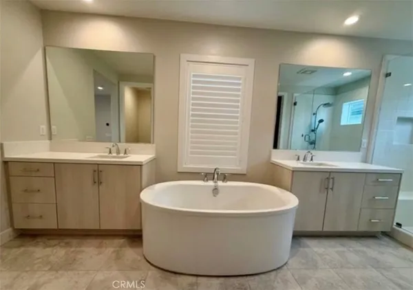 a bathroom with a tub sink and mirror