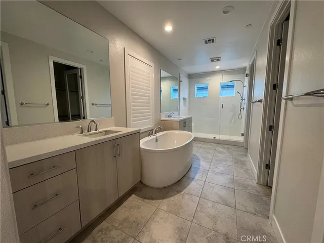 a bathroom with a bathtub shower sink and mirror