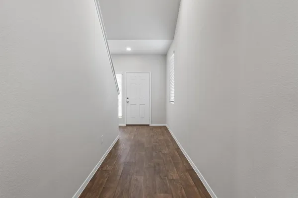 a view of a hallway with wooden floor