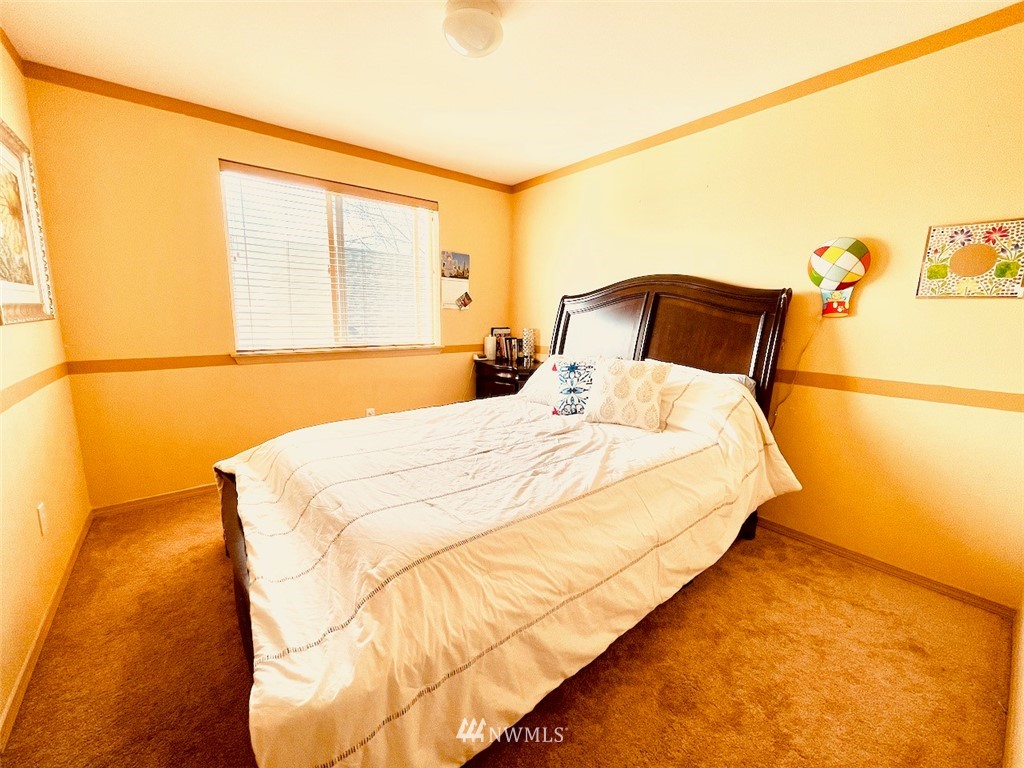 502 South 53rd Place Renton, WA 98055 - Photo 19 of 23 a large bed sitting in a bedroom next to a window