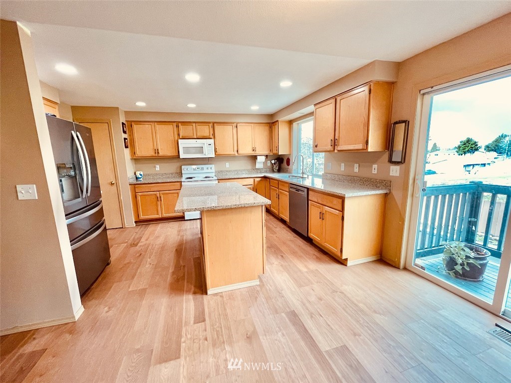 502 South 53rd Place Renton, WA 98055 - Photo 5 of 23 a kitchen with stainless steel appliances a refrigerator a sink dishwasher and a stove with wooden floor