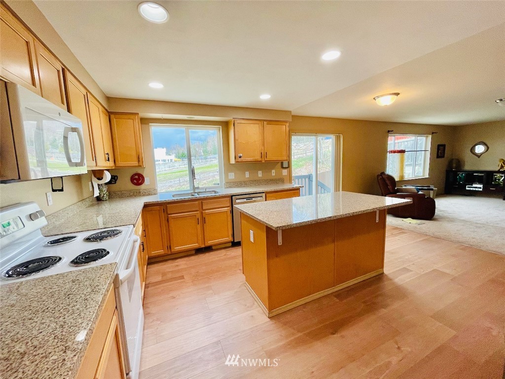 502 South 53rd Place Renton, WA 98055 - Photo 6 of 23 a kitchen with stainless steel appliances granite countertop sink stove and granite counter top