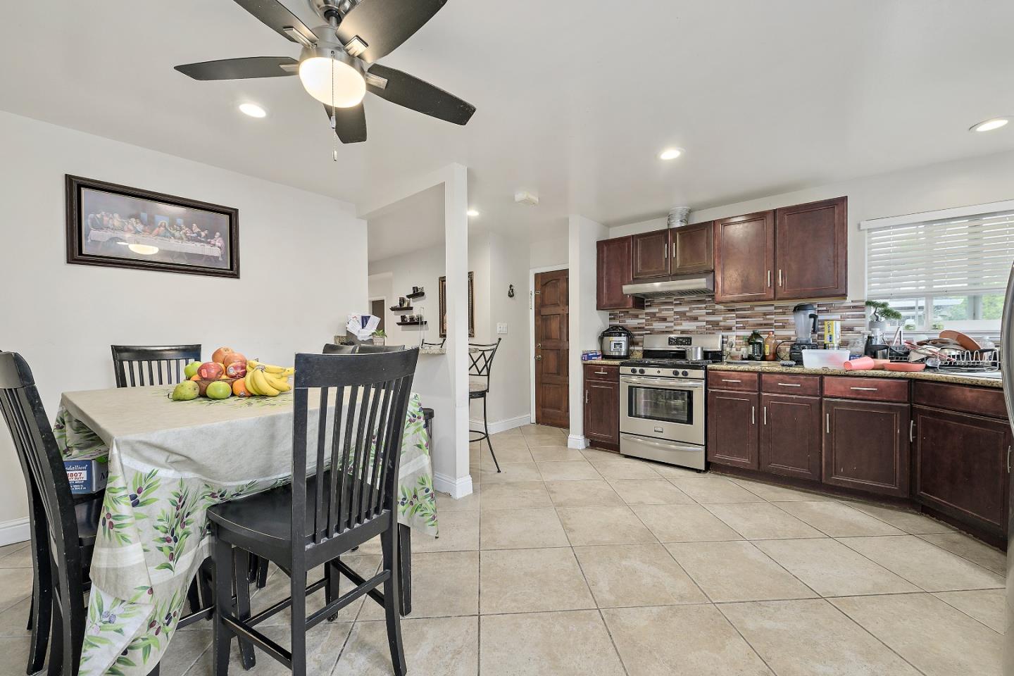 1481 Kooser Road San Jose, CA 95118 - Photo 6 of 16 a kitchen with stainless steel appliances granite countertop a stove a sink a microwave a refrigerator with a dining table and chairs
