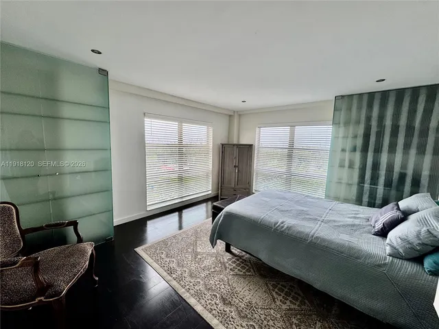 a bedroom with a bed wooden floor and window