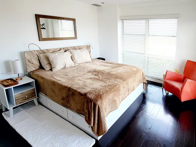 a bed sitting in a bedroom next to a window