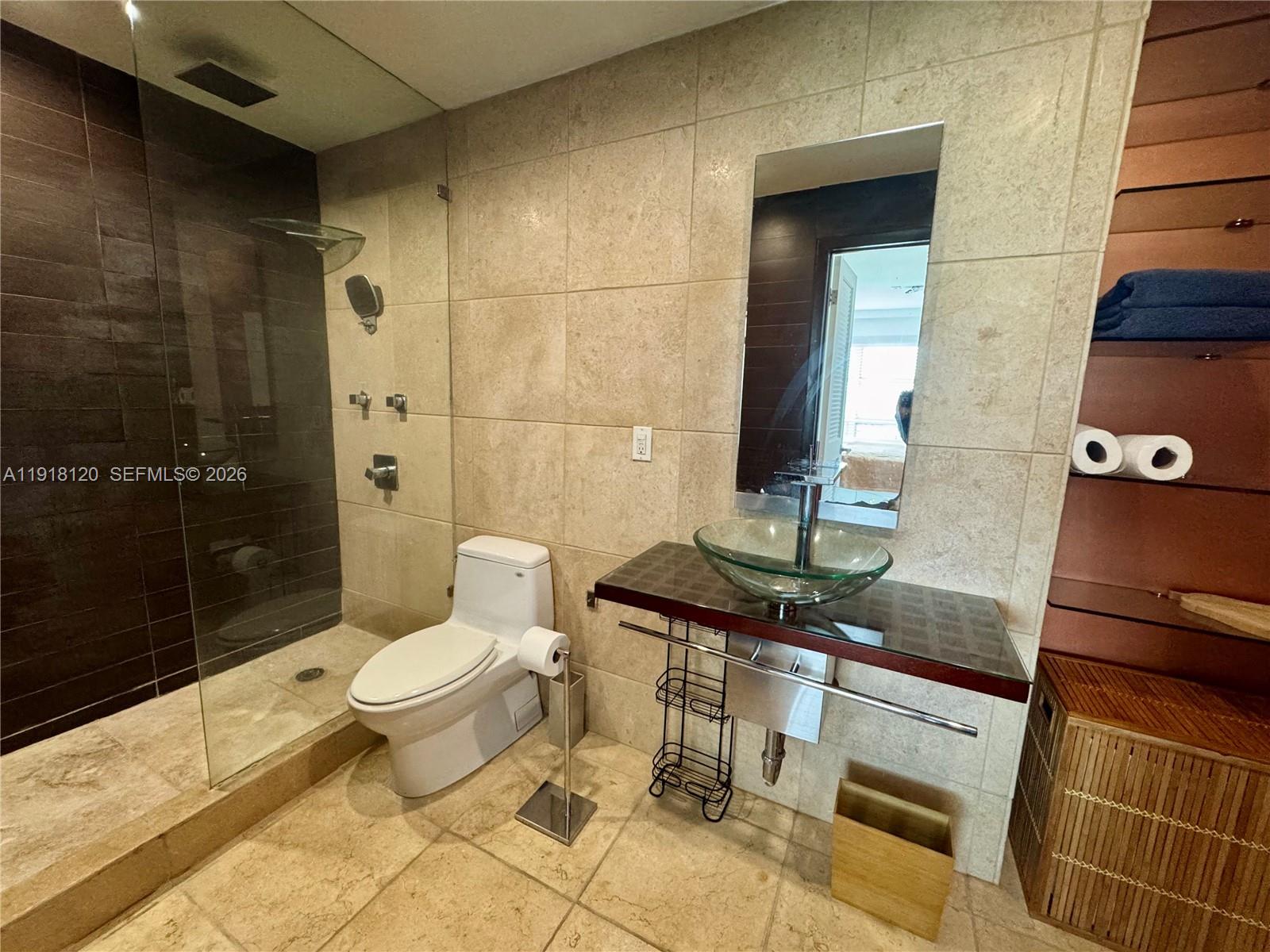77 Crandon Boulevard, Unit 10A Key Biscayne, FL 33149 - Photo 9 of 17 a bathroom with a toilet a sink and shower