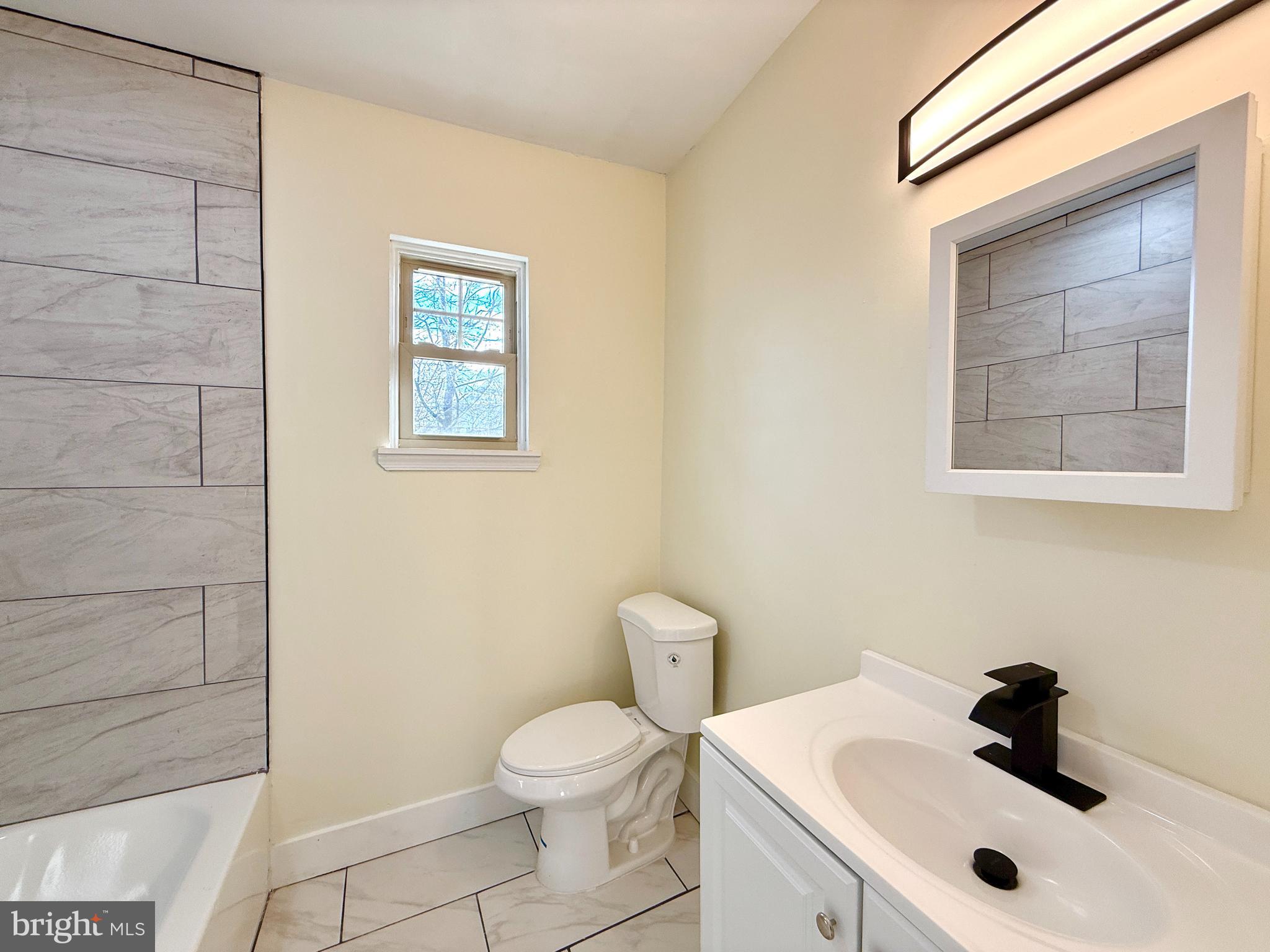 2913 West 6th Street Chester, PA 19013 - Photo 14 of 20 a bathroom with a sink a toilet and a shower