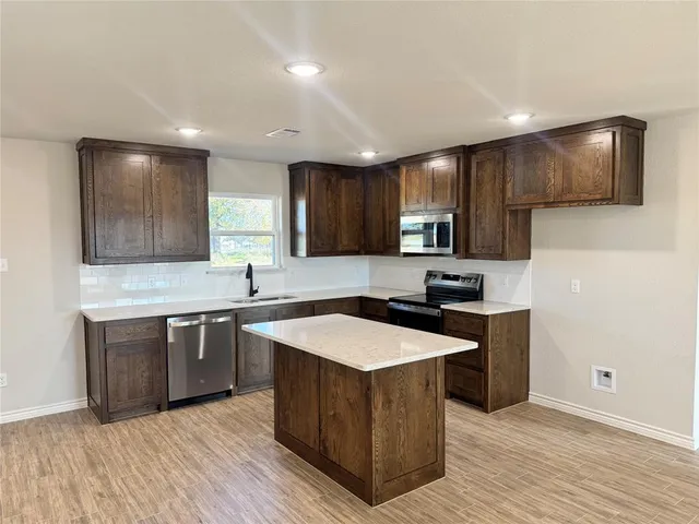 a kitchen with stainless steel appliances granite countertop a sink stove and cabinets