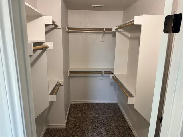 a view of walk in closet with empty racks