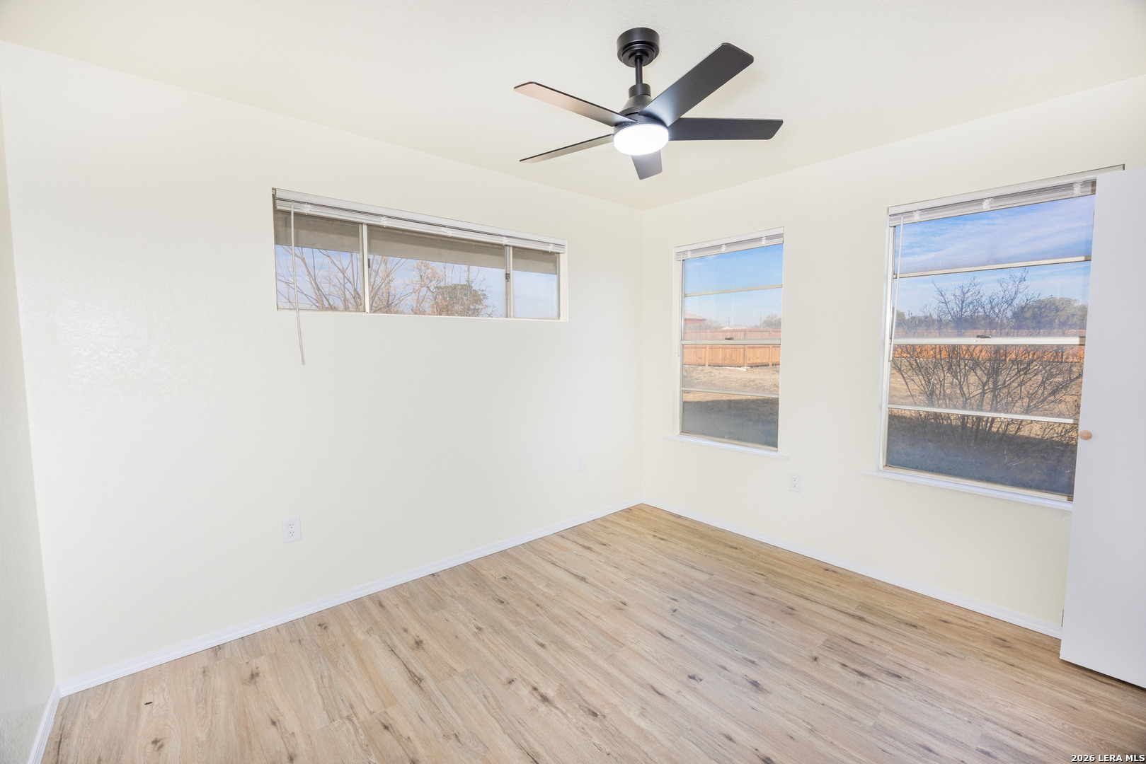 523 A Rossville Road Devine, TX 78016 - Photo 11 of 31 a view of an empty room with wooden floor and a window