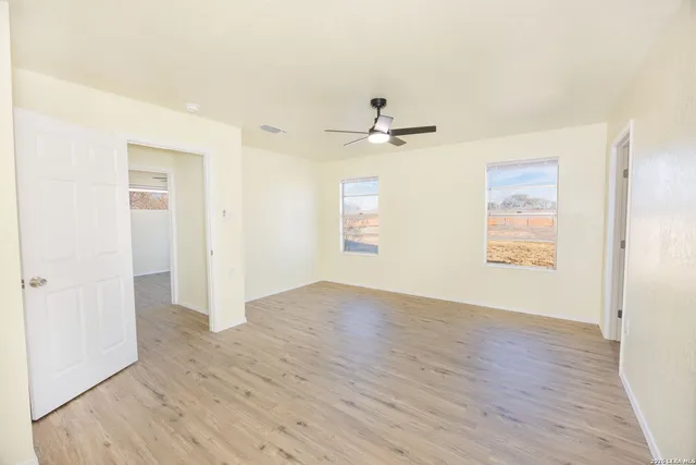 a view of an empty room with wooden floor