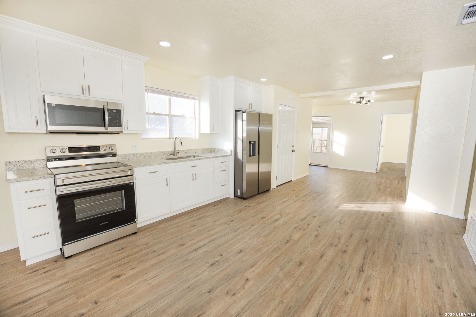 523 A Rossville Road Devine, TX 78016 - Photo 8 of 31 a kitchen with stainless steel appliances a stove top oven a kitchen island a sink and a refrigerator