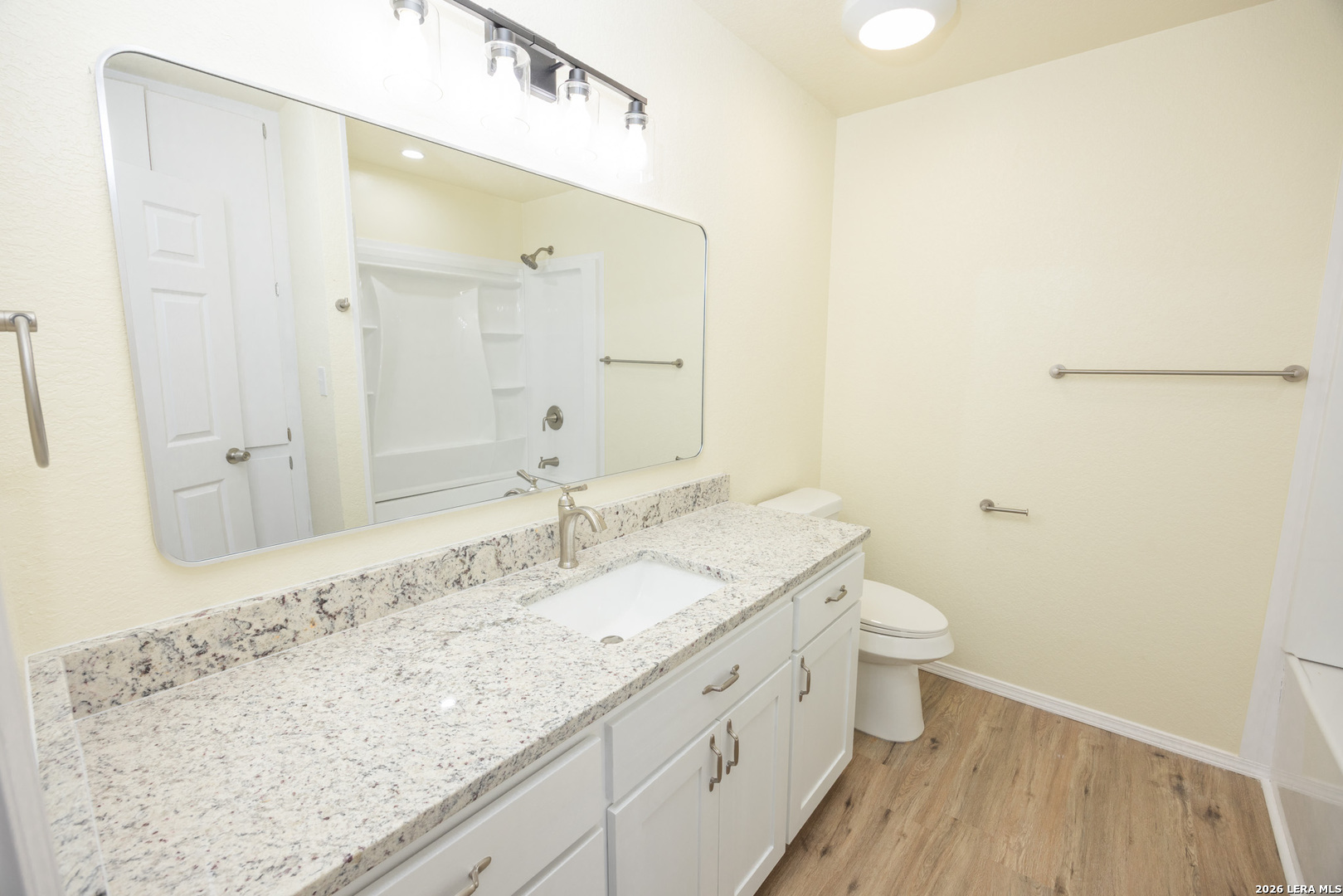 523 A Rossville Road Devine, TX 78016 - Photo 10 of 31 a bathroom with a granite countertop sink a toilet and shower