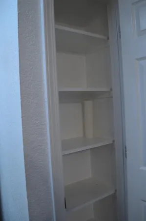 a view of walk in closet with empty racks