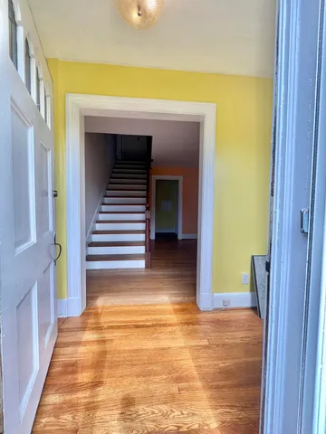 a view of entryway and hall with wooden floor