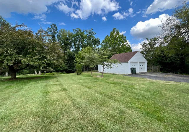a view of a house with backyard and tree