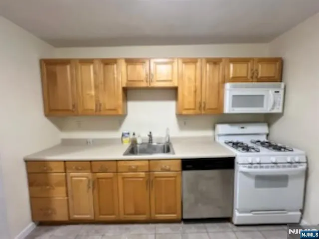 a kitchen with white cabinets and white appliances