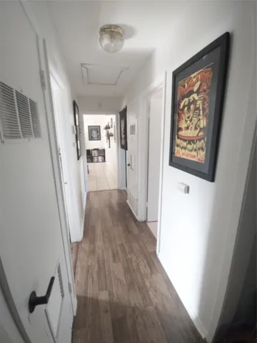 a view of a hallway with wooden floor and stairs