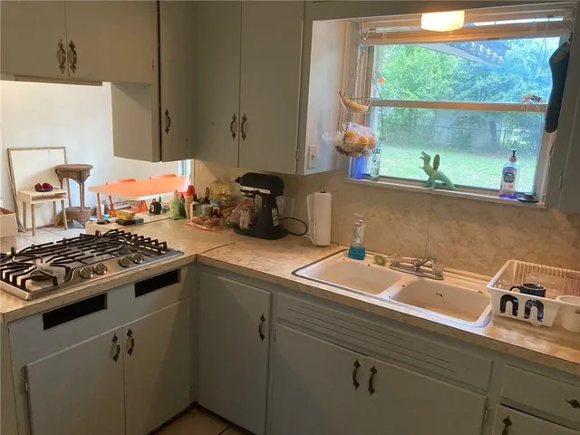 a kitchen with a sink stove and cabinets