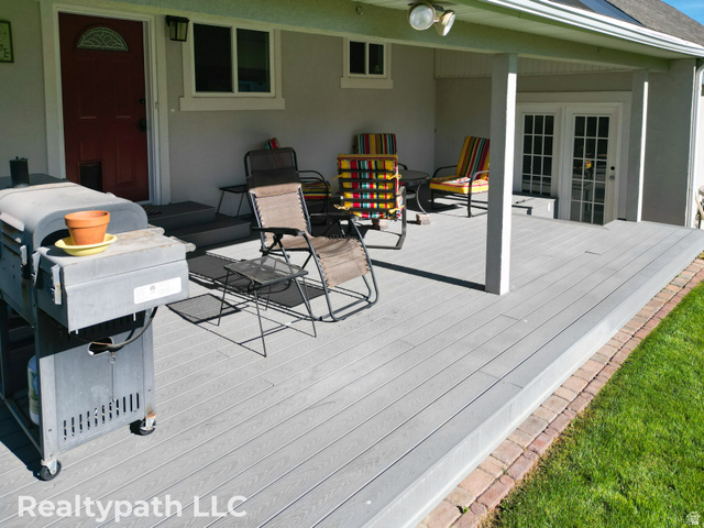 475 South 300 East Payson, UT 84651 - Photo 8 of 12 Spacious outdoor deck featuring gray composite decking, supporting columns, and a brick border