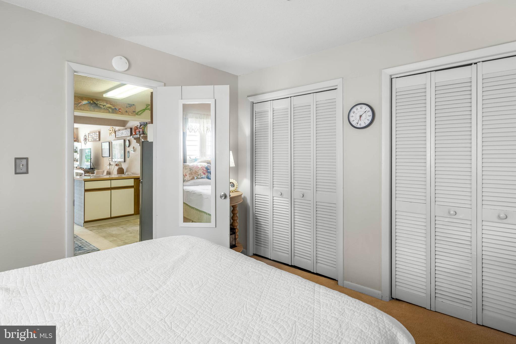 11 144th Street, Unit 102 Ocean City, MD 21842 - Photo 12 of 27 a bedroom with a bed and a mirror