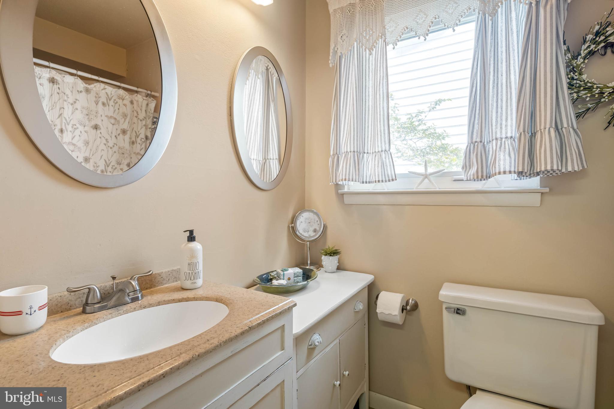 11 144th Street, Unit 102 Ocean City, MD 21842 - Photo 13 of 27 a bathroom with a toilet a sink and a mirror