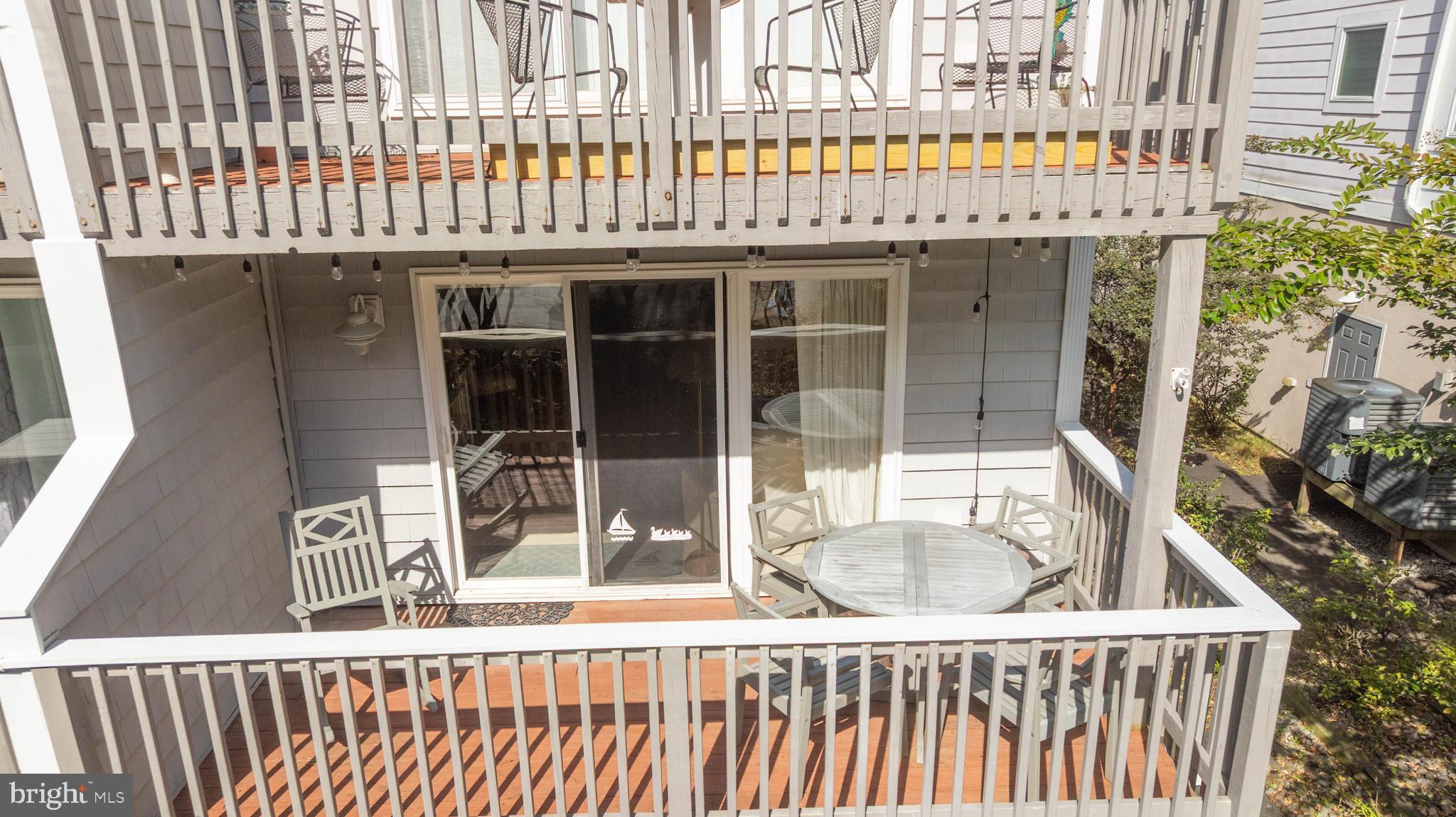 11 144th Street, Unit 102 Ocean City, MD 21842 - Photo 16 of 27 a view of a balcony with a floor to ceiling window and an outdoor kitchen