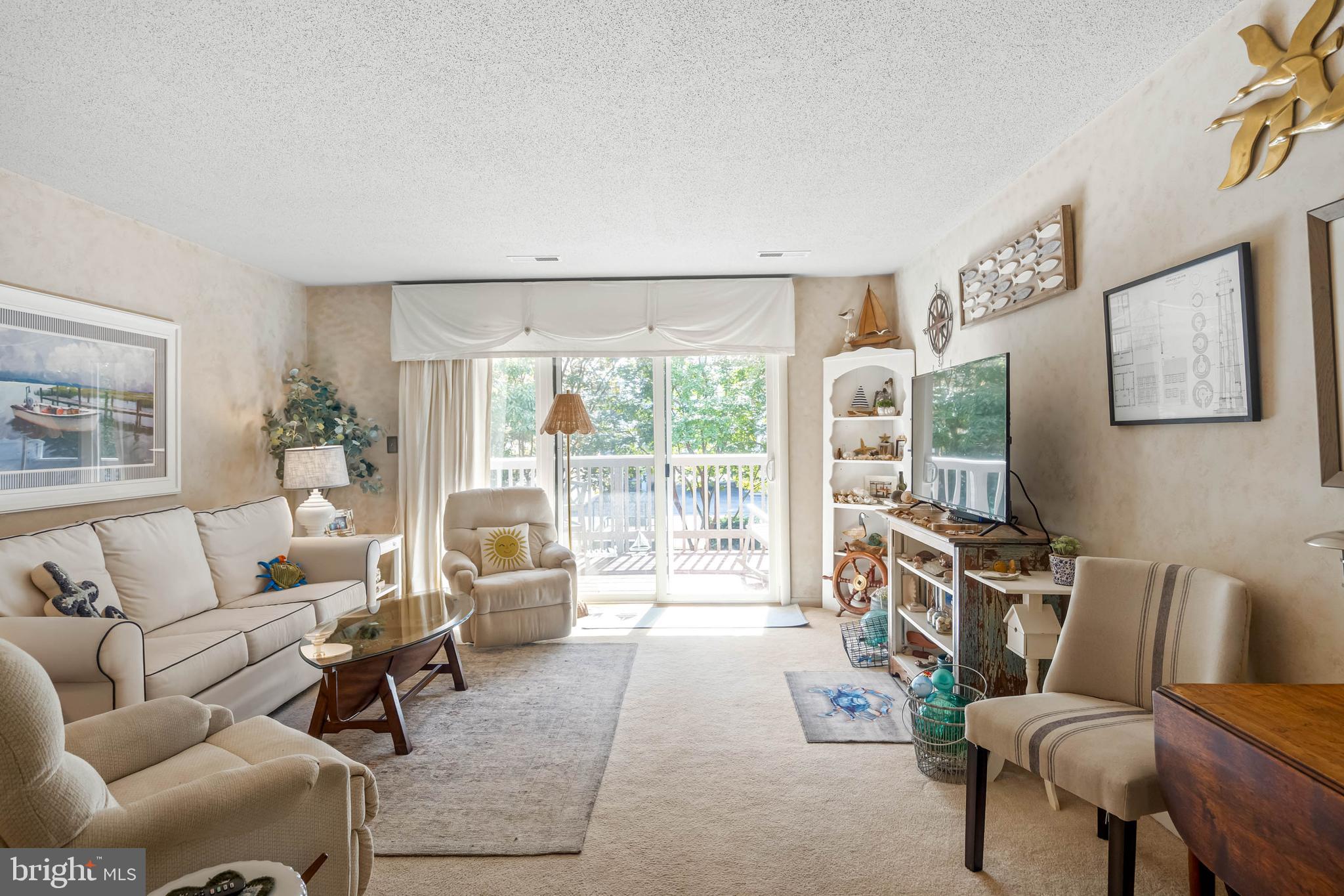 11 144th Street, Unit 102 Ocean City, MD 21842 - Photo 2 of 27 a living room with furniture and a flat screen tv