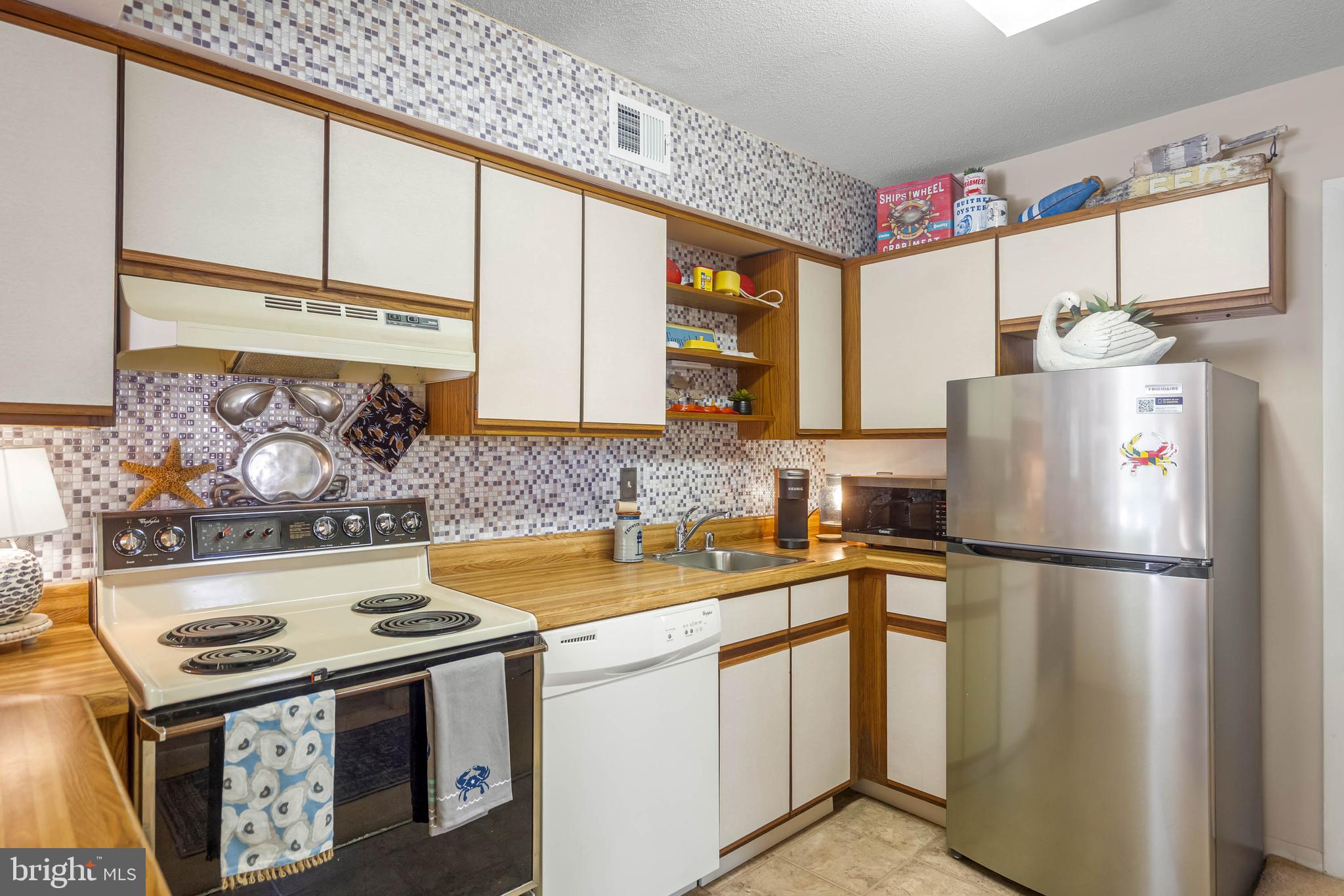 11 144th Street, Unit 102 Ocean City, MD 21842 - Photo 6 of 27 a kitchen with refrigerator a stove a sink and cabinets