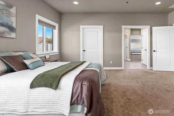 a bedroom with a bed and a large window