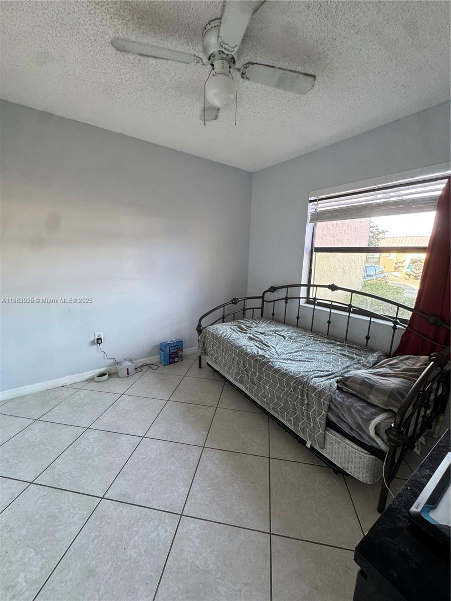 142 Northwest 91st Avenue, Unit 104 Pembroke Pines, FL 33024 - Photo 6 of 15 a bedroom with a bed and a dresser