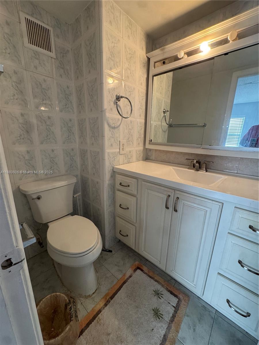 142 Northwest 91st Avenue, Unit 104 Pembroke Pines, FL 33024 - Photo 7 of 15 a bathroom with a toilet sink and mirror