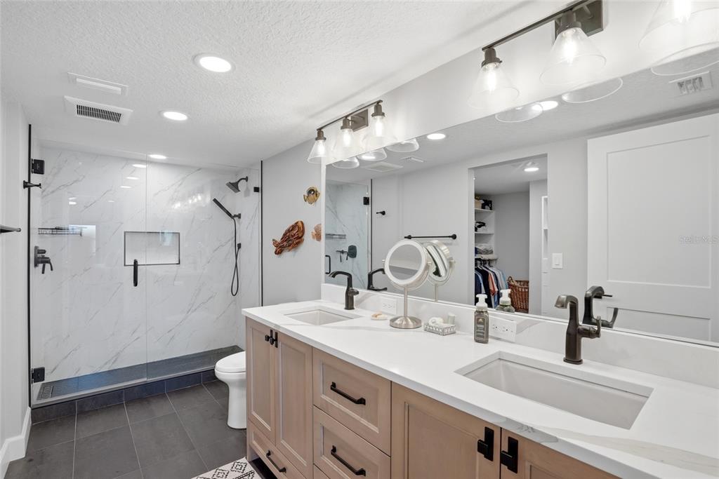 363 Pinellas Bayway South, Unit 29 Tierra Verde, FL 33715 - Photo 24 of 59 a bathroom with a double vanity sink mirror and shower