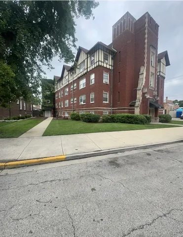 a view of a house with a yard and large trees