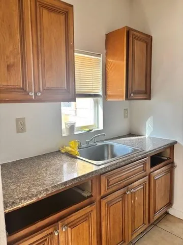 a kitchen with granite countertop a sink a stove and cabinets