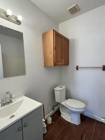 a bathroom with a toilet a sink and mirror