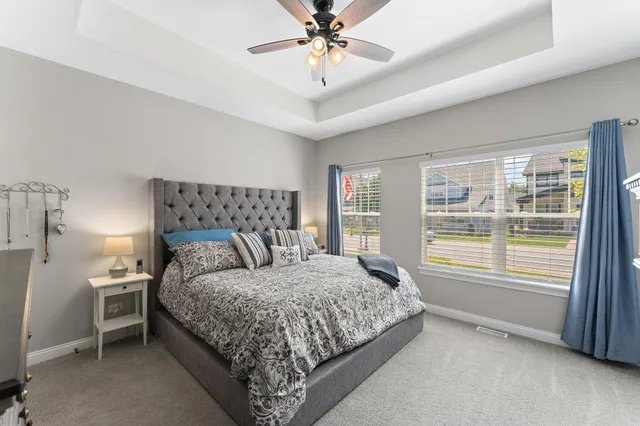a bedroom with a large bed and a chandelier fan