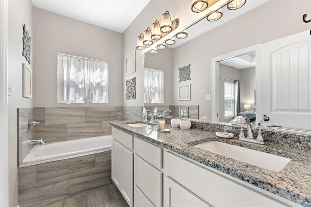a bathroom with double vanity sinks and a bathtub