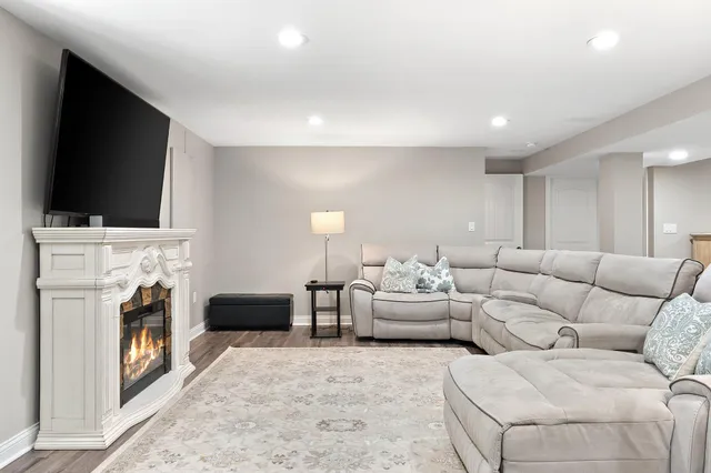 a living room with furniture a flat screen tv and a fireplace