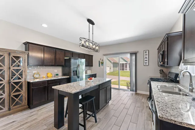 a kitchen with stainless steel appliances granite countertop a sink stove and refrigerator