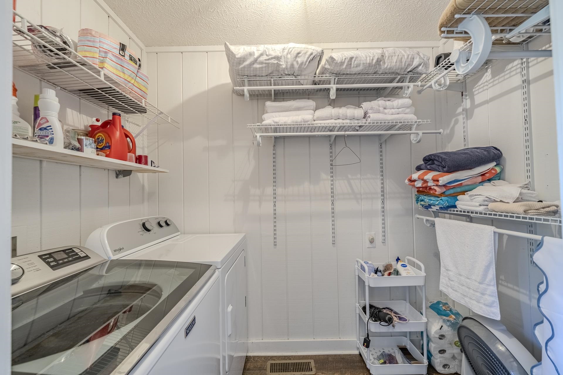 80 Contreau Road Counce, TN 38326 - Photo 16 of 28 Dedicated laundry area featuring a white paneled wall finish, multiple adjustable wire shelving units, and a dark tile flooring