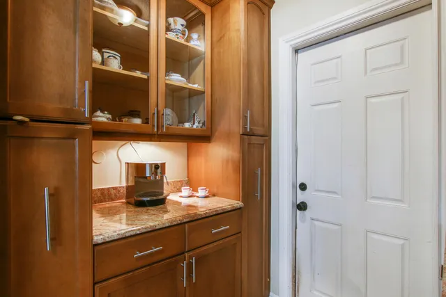 a kitchen with stainless steel appliances granite countertop a stove top oven a sink dishwasher a dining table and chairs with wooden floor