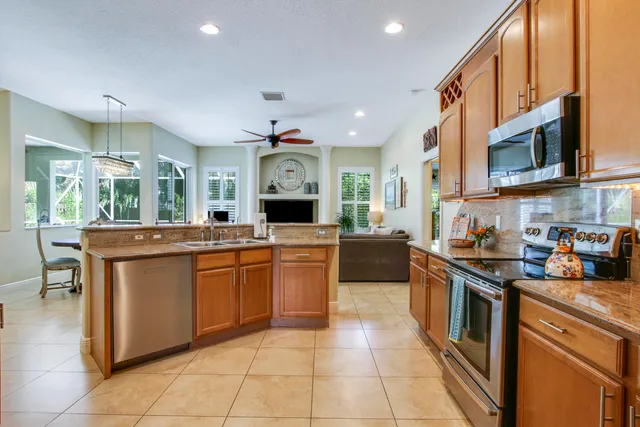 a kitchen with stainless steel appliances granite countertop a refrigerator and a sink