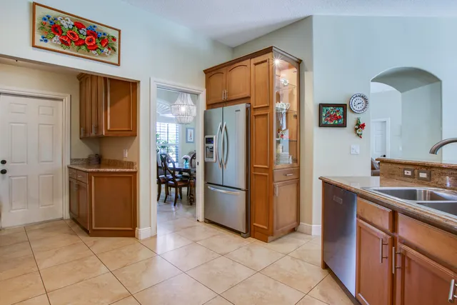 a kitchen with stainless steel appliances granite countertop sink stove refrigerator and cabinets