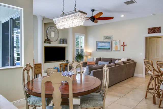 a living room with furniture kitchen view and a chandelier