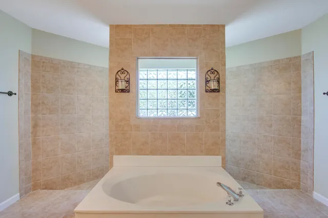 a bathroom with double vanity sink a two mirror a window and a bathtub